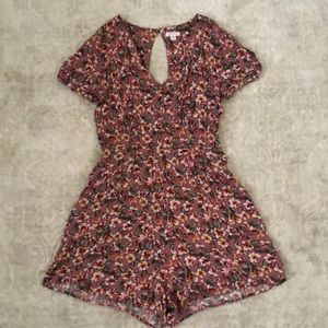 This is a pink floral romper with arm sleeve cut outs and a small back cut out.